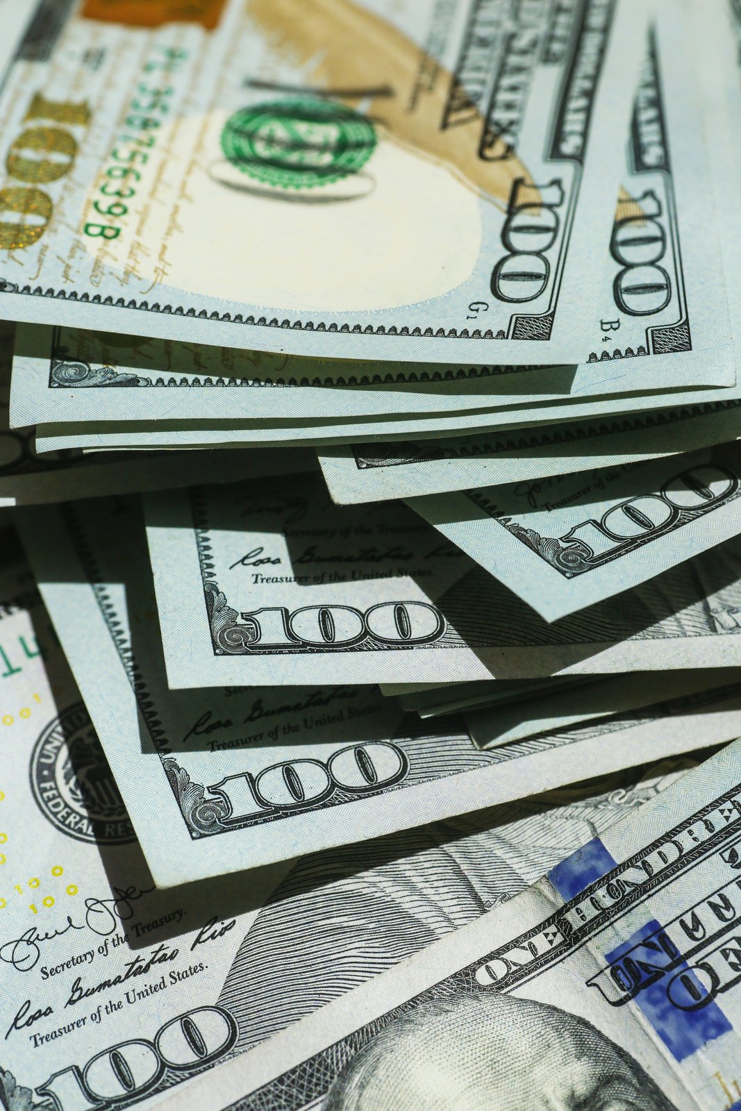 A loose stack of one hundred dollar bills fanned out