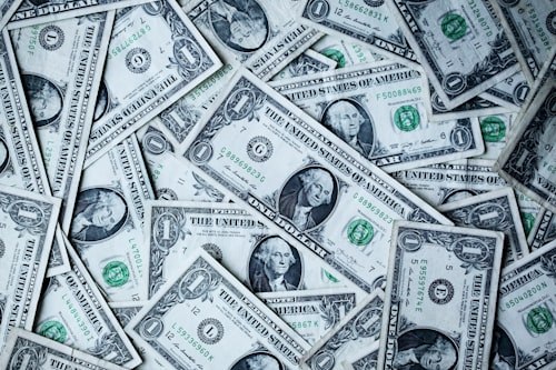 A pile of scattered U.S. dollar bills